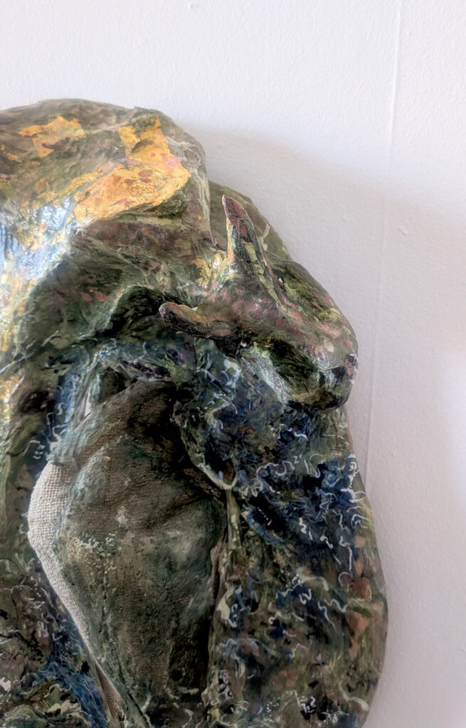 Sculpture including a dragon and a hand